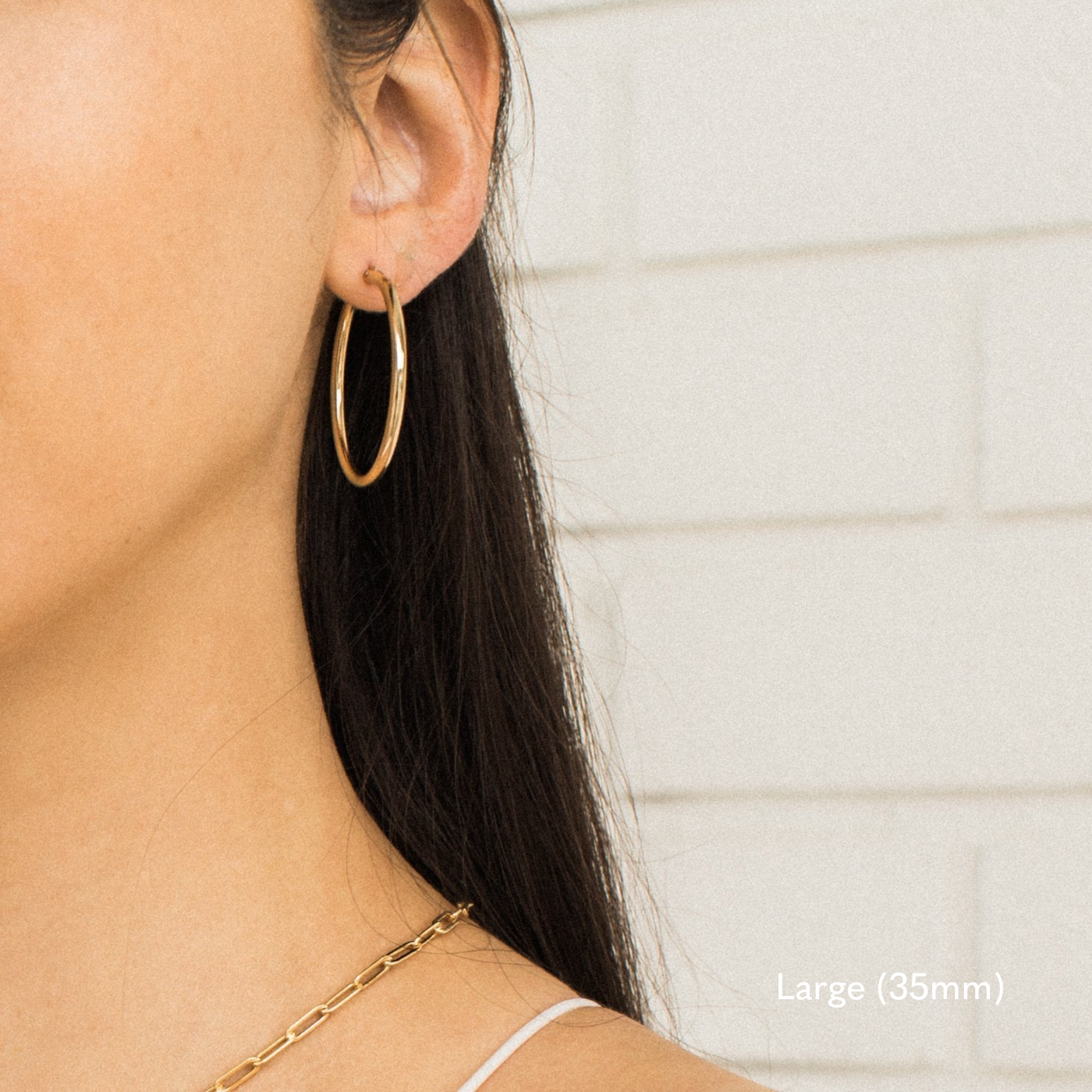Woman wearing a single large 35mm gold Everyday Hoop Earring on one ear. The photo is taken from the side, showing her earring, hair pulled back, and a small portion of her shoulder.

Large (35mm) Everyday Hoop Earrings by Simple & Dainty Jewelry
