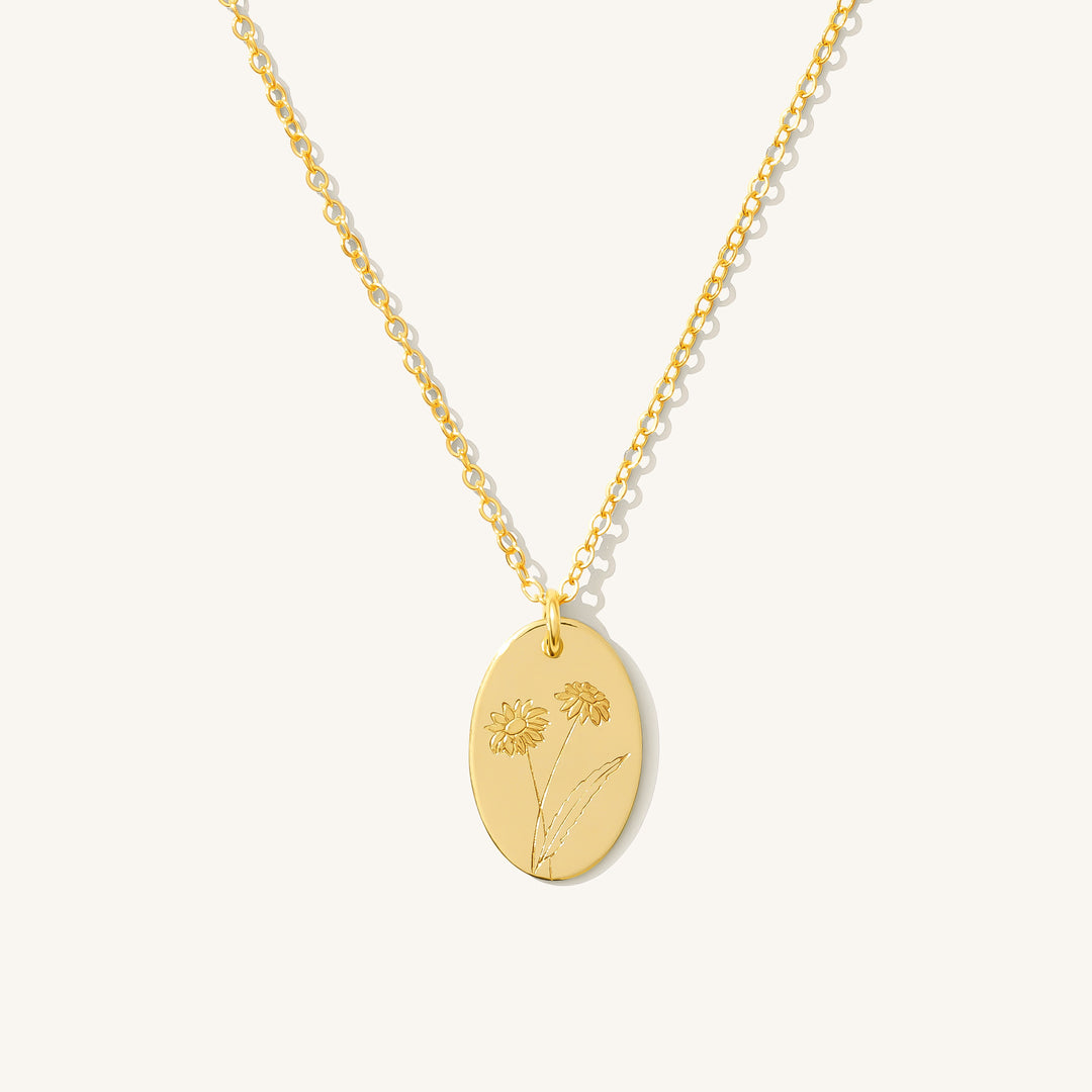 April Birthflower Necklace in gold-filled, featuring a stamped daisy flower on an oval disc pendant.