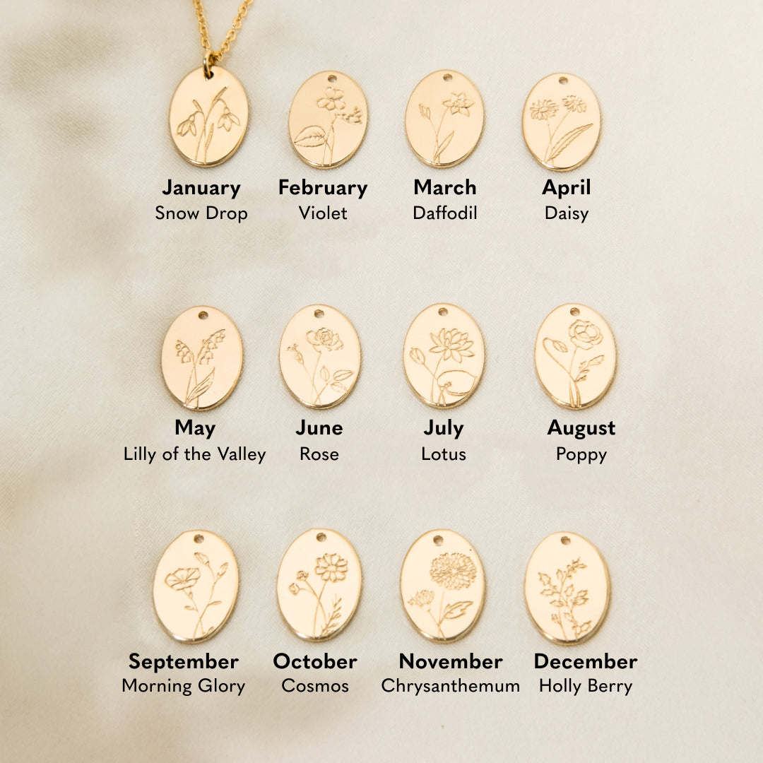 Gold necklaces with engraved floral designs for each month, on a beige background. January - Snow Drop February - Violet March - Daffodil April - Daisy May - Lily of the Valley June - Rose July - Lotus August - Poppy September - Morning Glory October - Cosmos November - Chrysanthemum December - Holly Berry