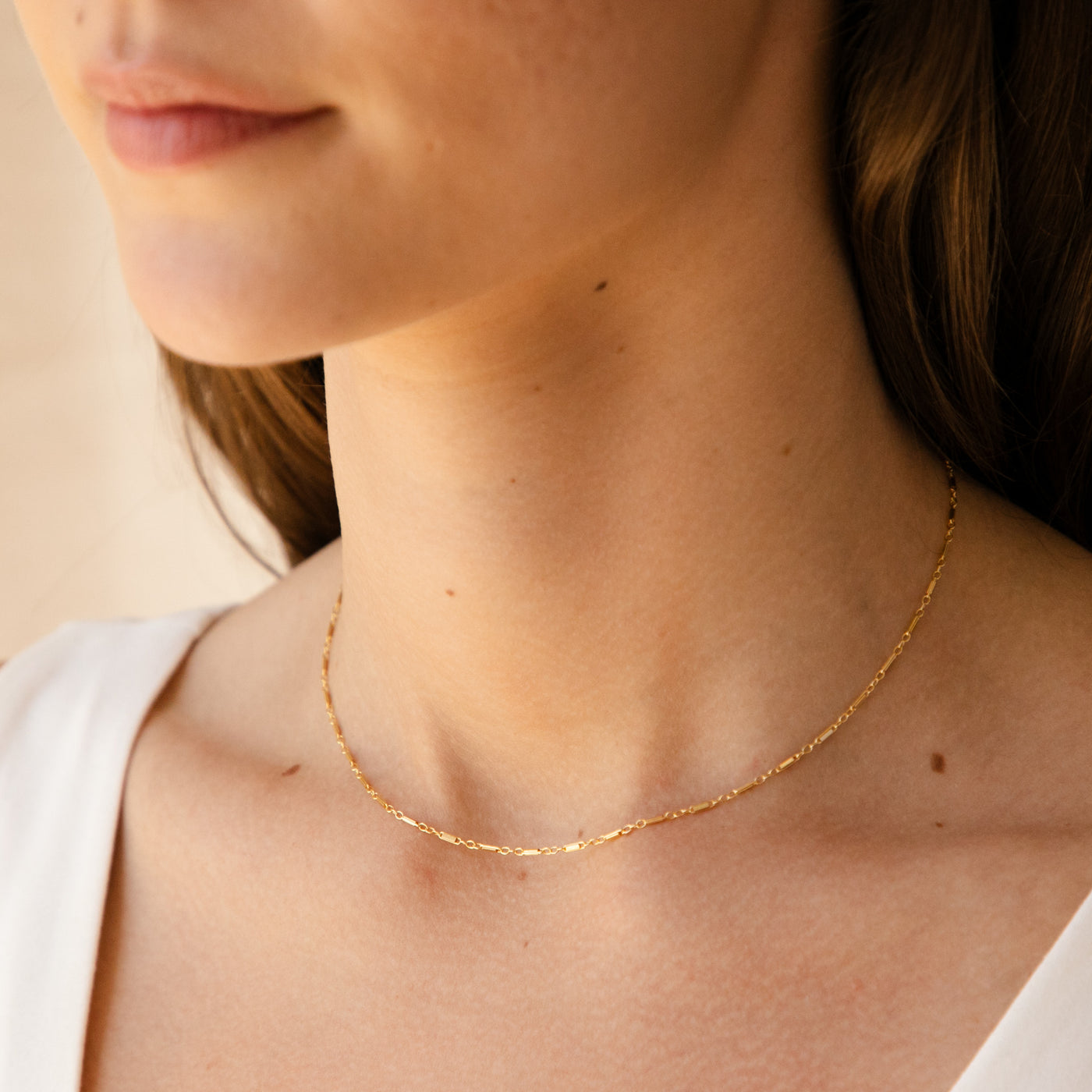 woman's neck wearing thin Shimmer Chain Necklace in gold filled
