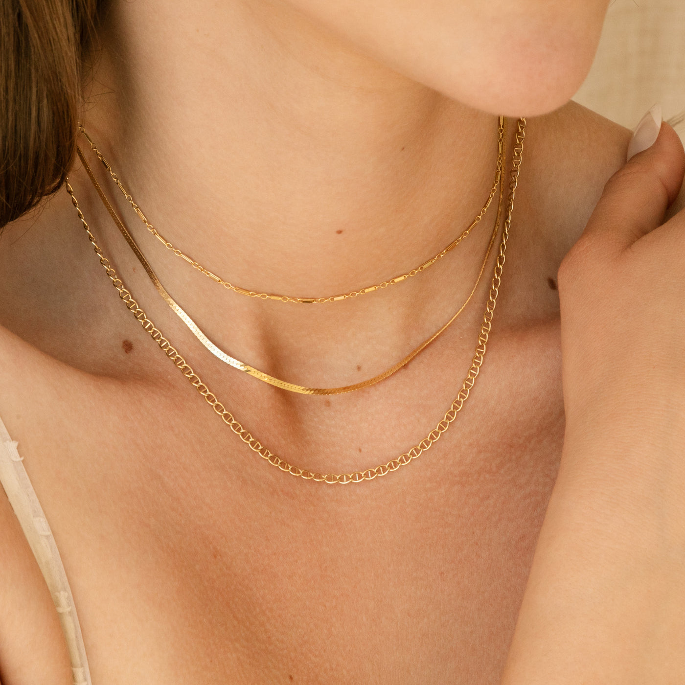 Neck close up with three chain necklaces including herringbone chain, sparkly chain, and Mariner Soda Tab Chain Necklace