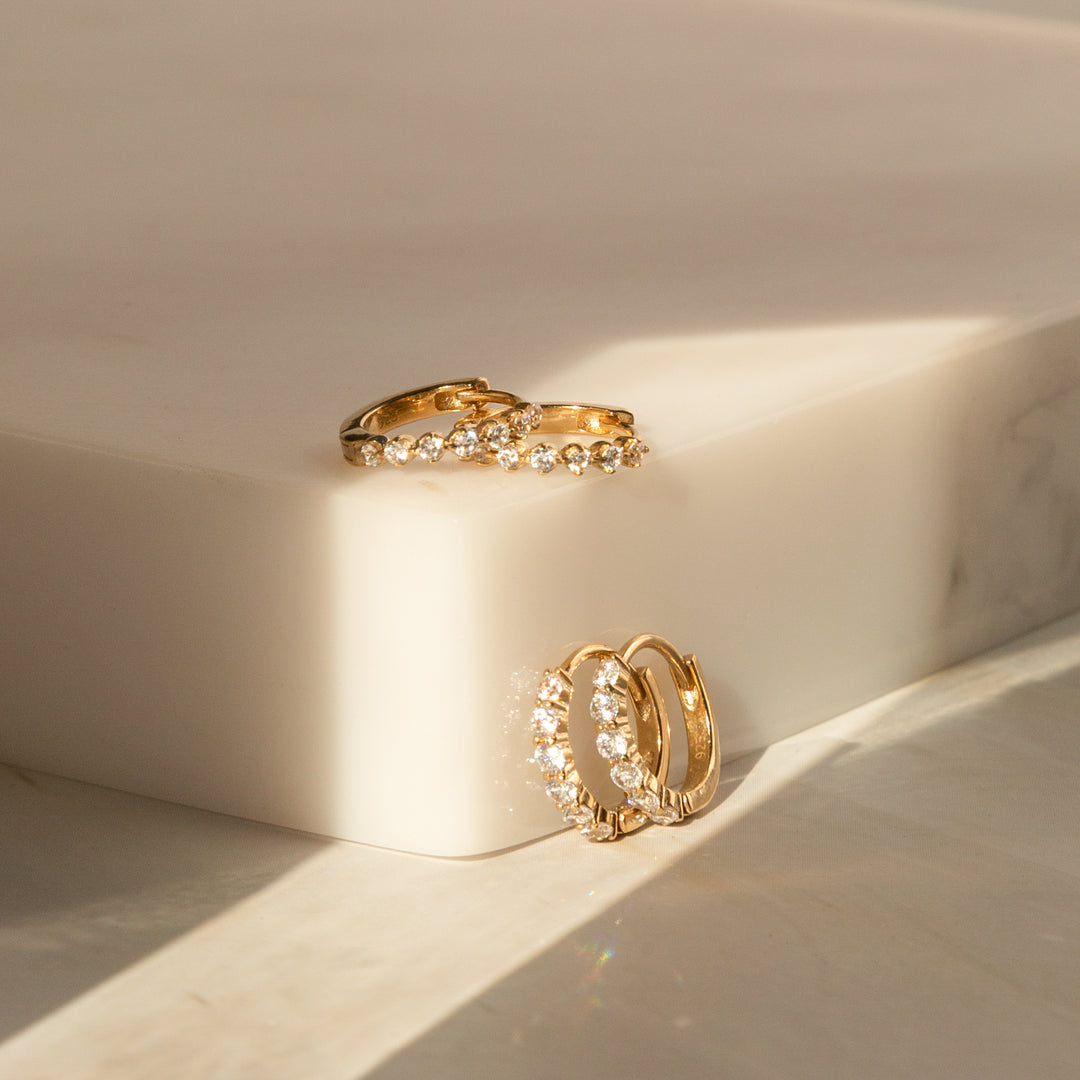 Two gold huggie hoops with CZ stones: Classic CZ Huggie Hoop Earrings and Dainty CZ Huggie Hoop Earrings.